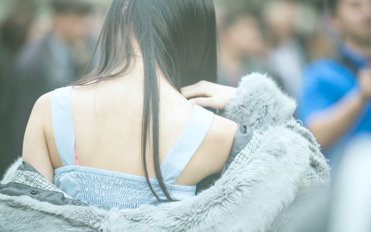 Back view of a woman in Taito City, Tokyo, wearing a stylish fur coat.