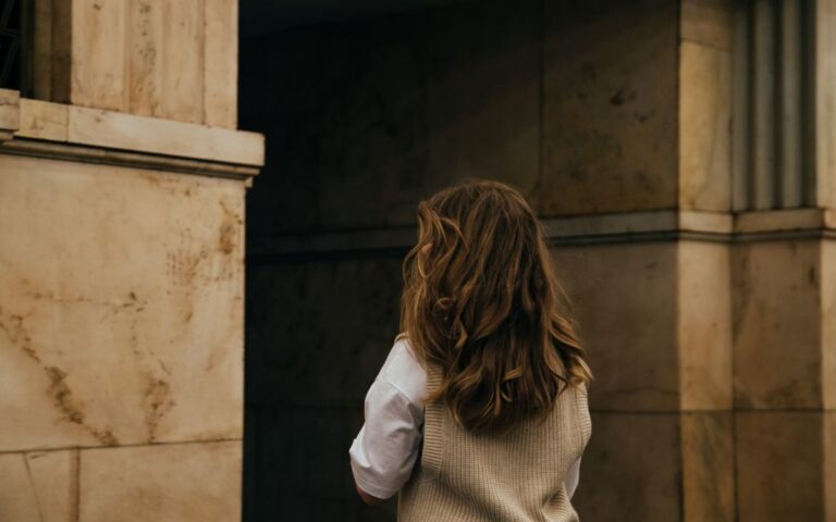 Captivating image of a woman with long hair against a classic stone wall in Moscow.