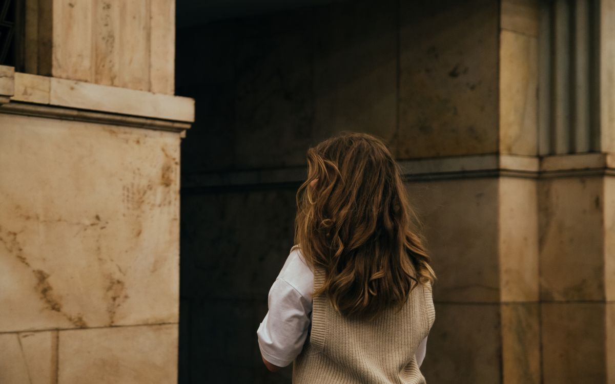 Captivating image of a woman with long hair against a classic stone wall in Moscow.