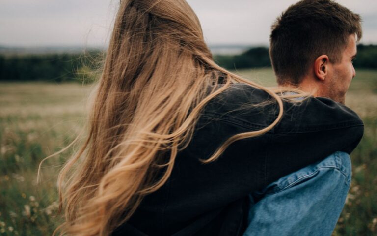 A couple embracing while enjoying a peaceful moment outdoors with nature as their backdrop.